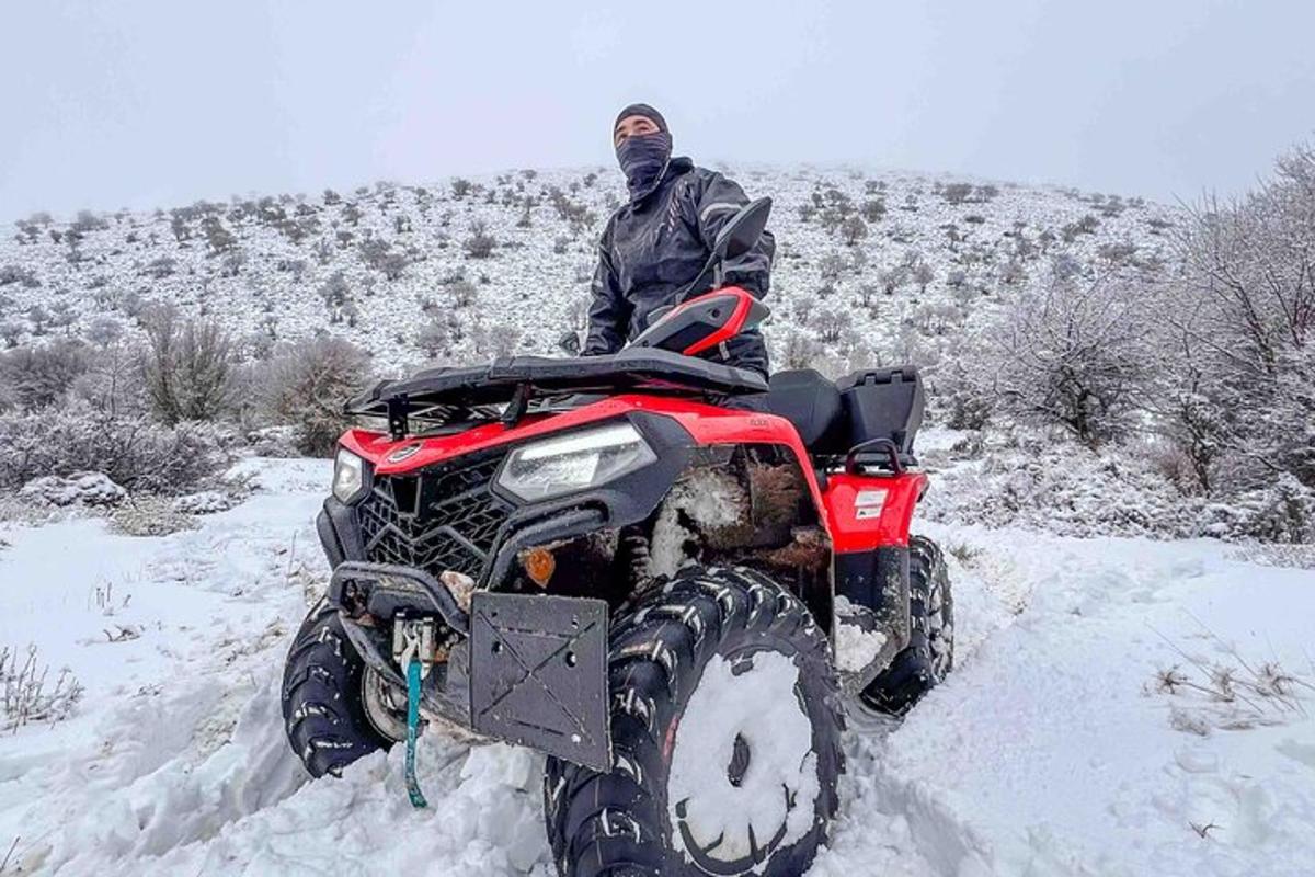 ein Mann steht auf einem Geländefahrzeug im Schnee