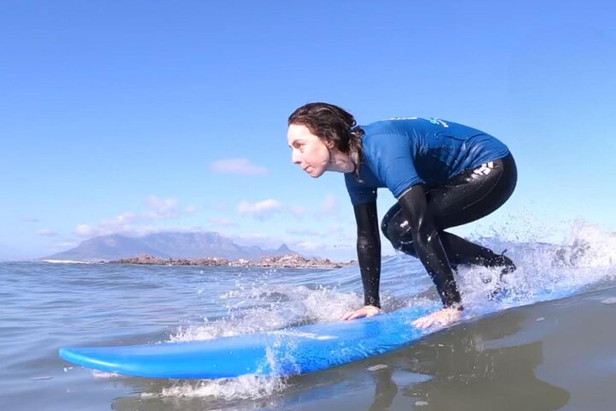 kobieta jadąca na niebieskiej desce surfingowej w wodzie