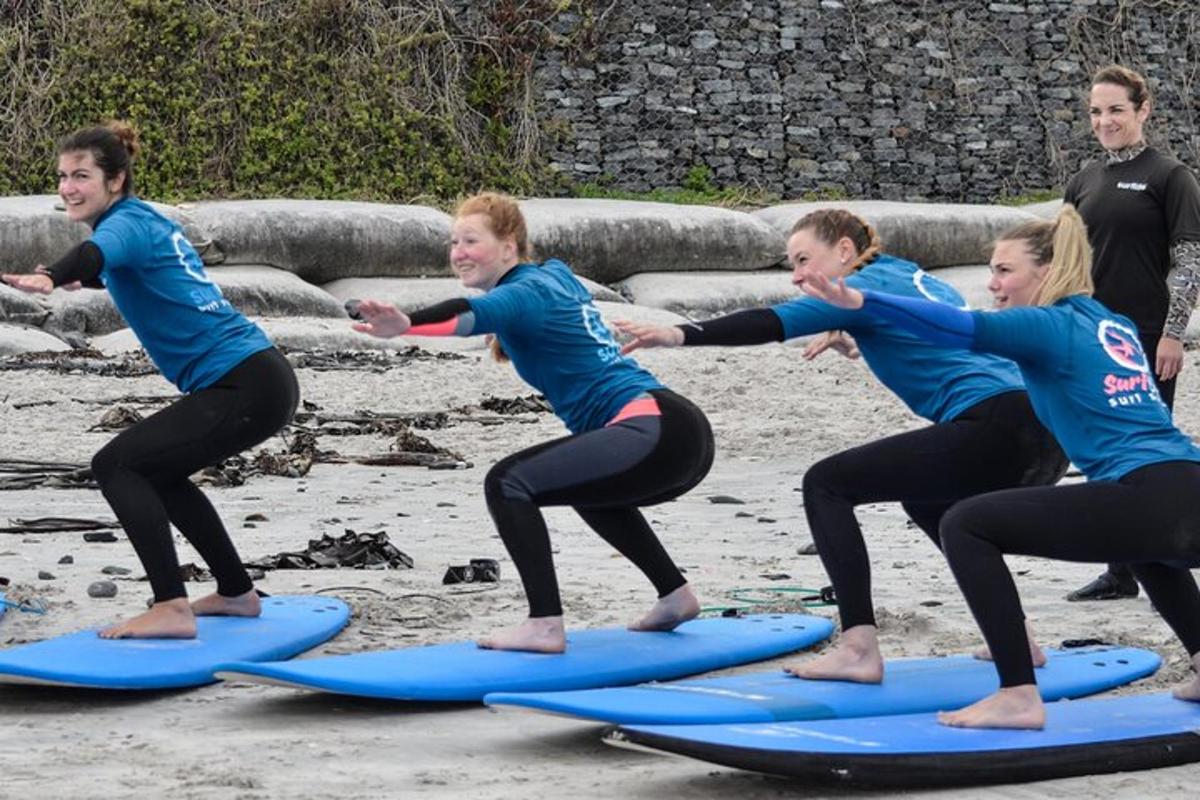 un gruppo di donne in piedi sulle tavole da surf sulla spiaggia