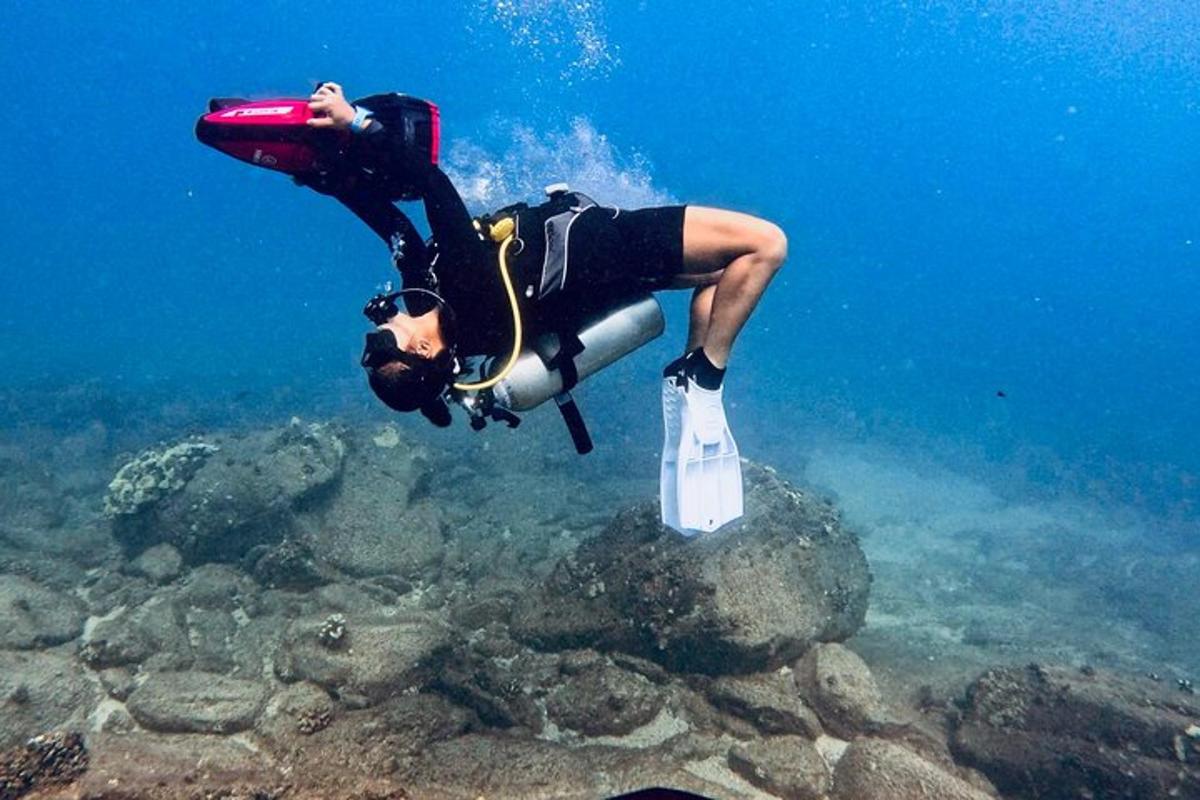 seorang lelaki dalam pakaian selam sedang menyelam di dalam air