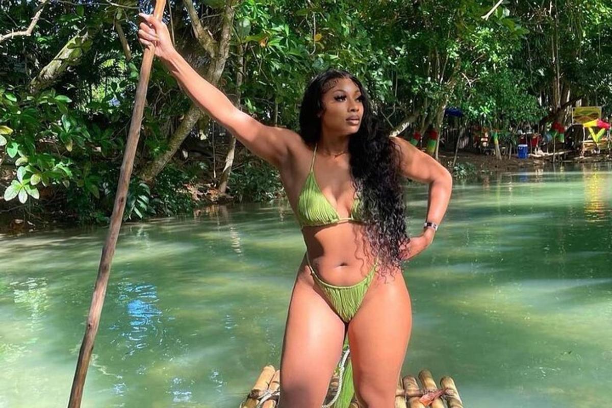 uma mulher de biquíni verde em um barco na água