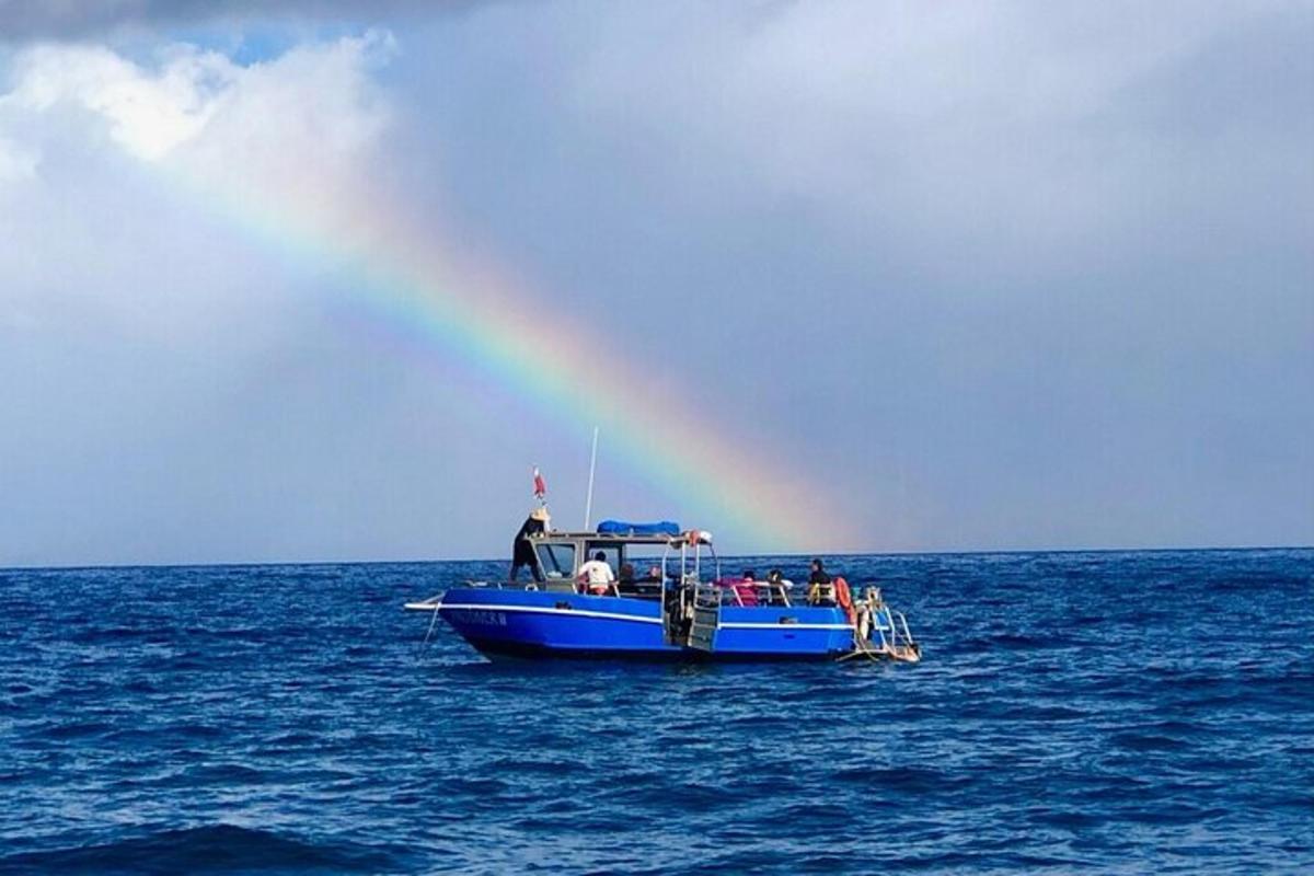 isang grupo ng mga tao sa isang asul na bangka na may bahaghari
