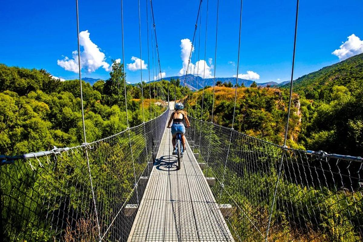isang taong nakasakay sa bisikleta sa isang suspension bridge