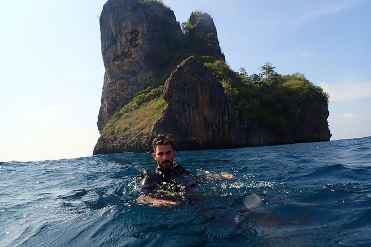 ein Mann im Wasser vor einer Felsformation
