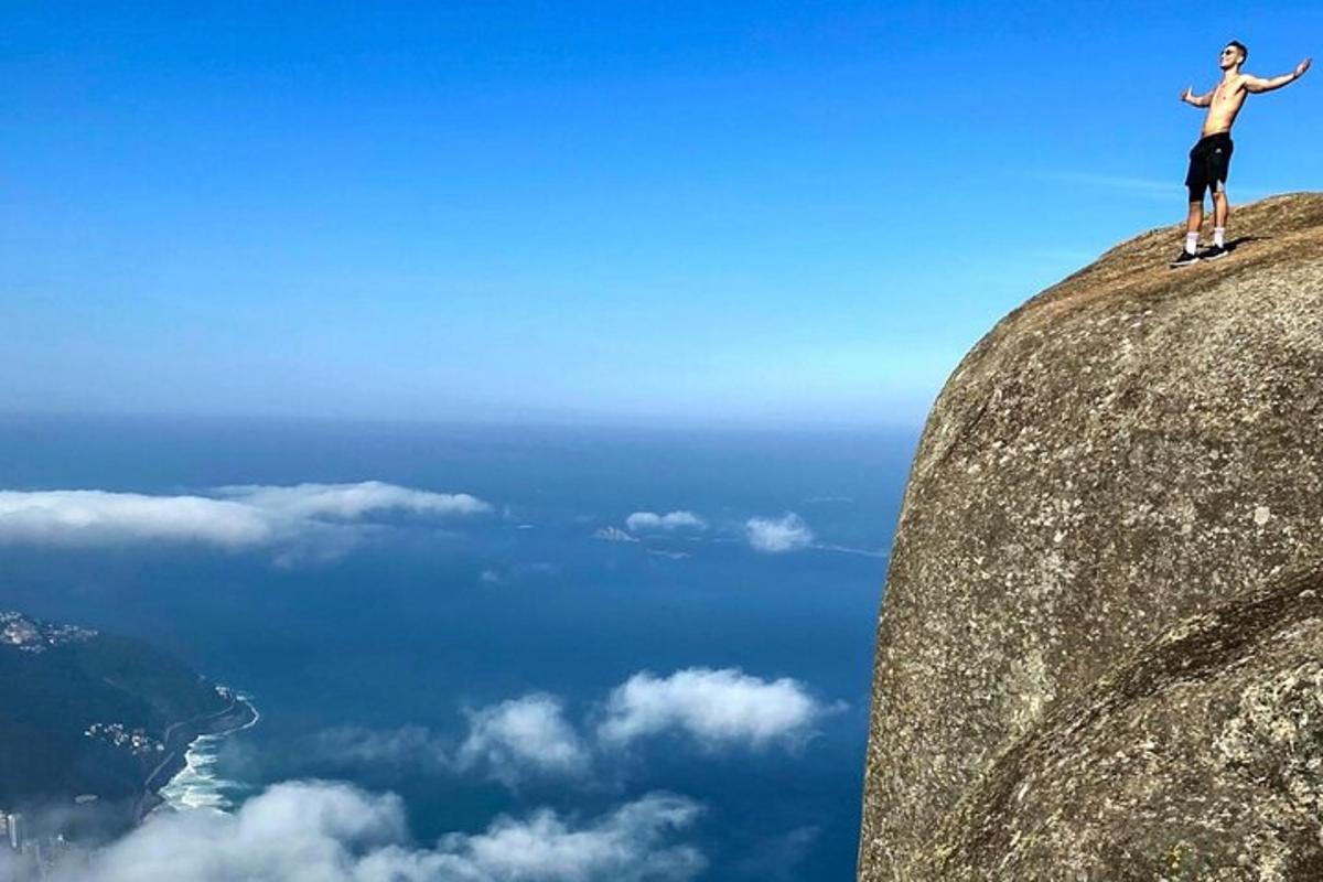maður stendur á fjallstindi