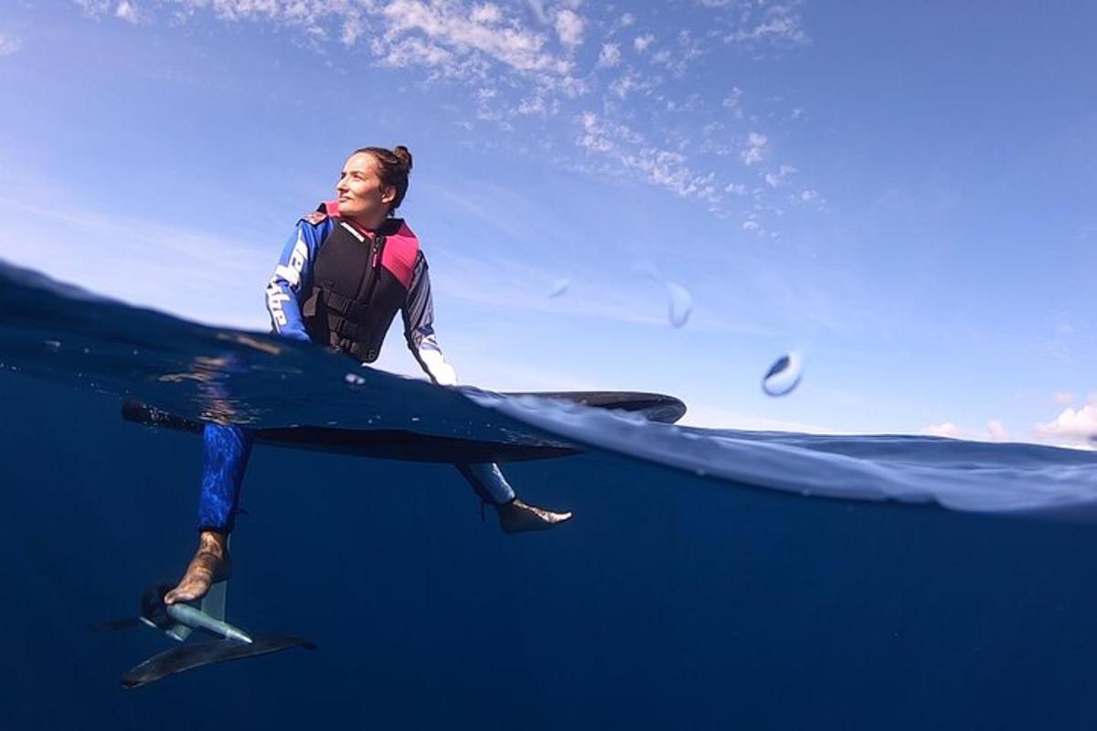 en kvinne står på et surfebrett i havet