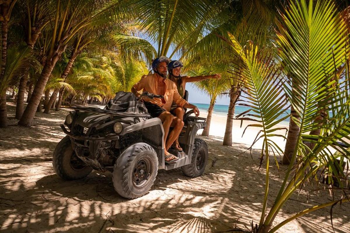 dos homes asseguts en un quad a la platja
