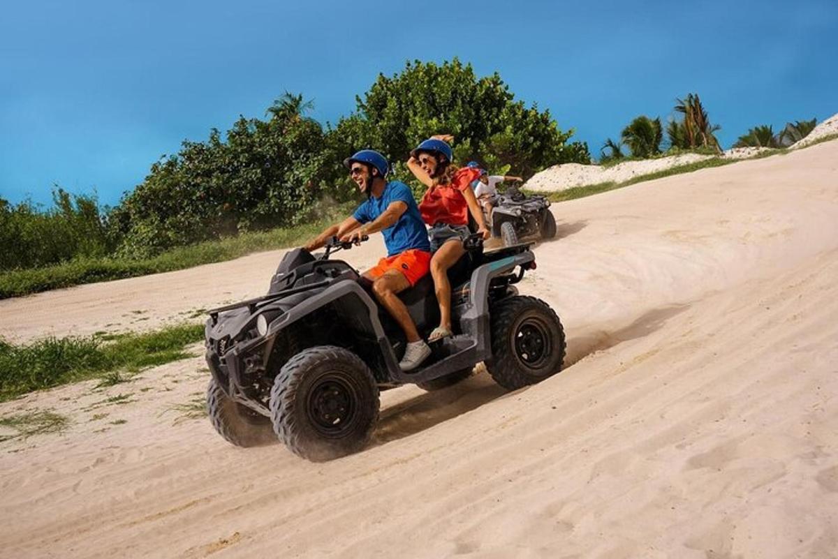dues persones que viatgen en un quad a la platja