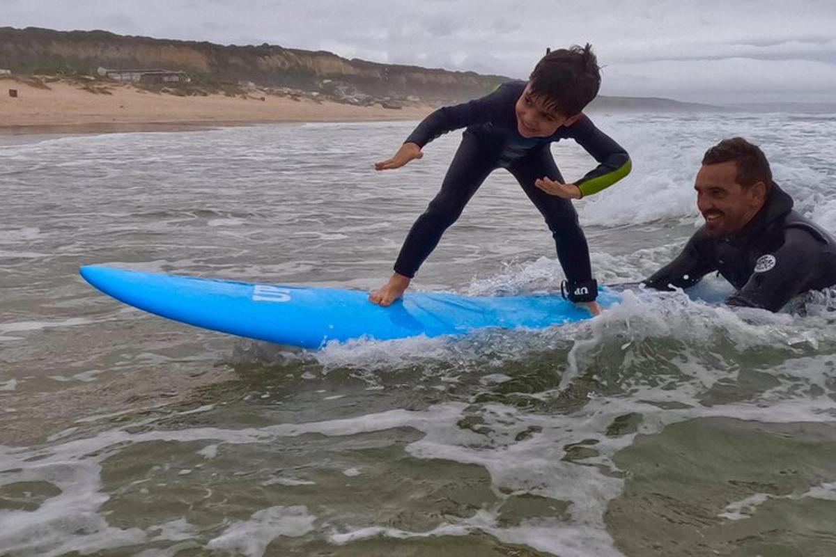 mężczyzna i dziecko na desce surfingowej w wodzie