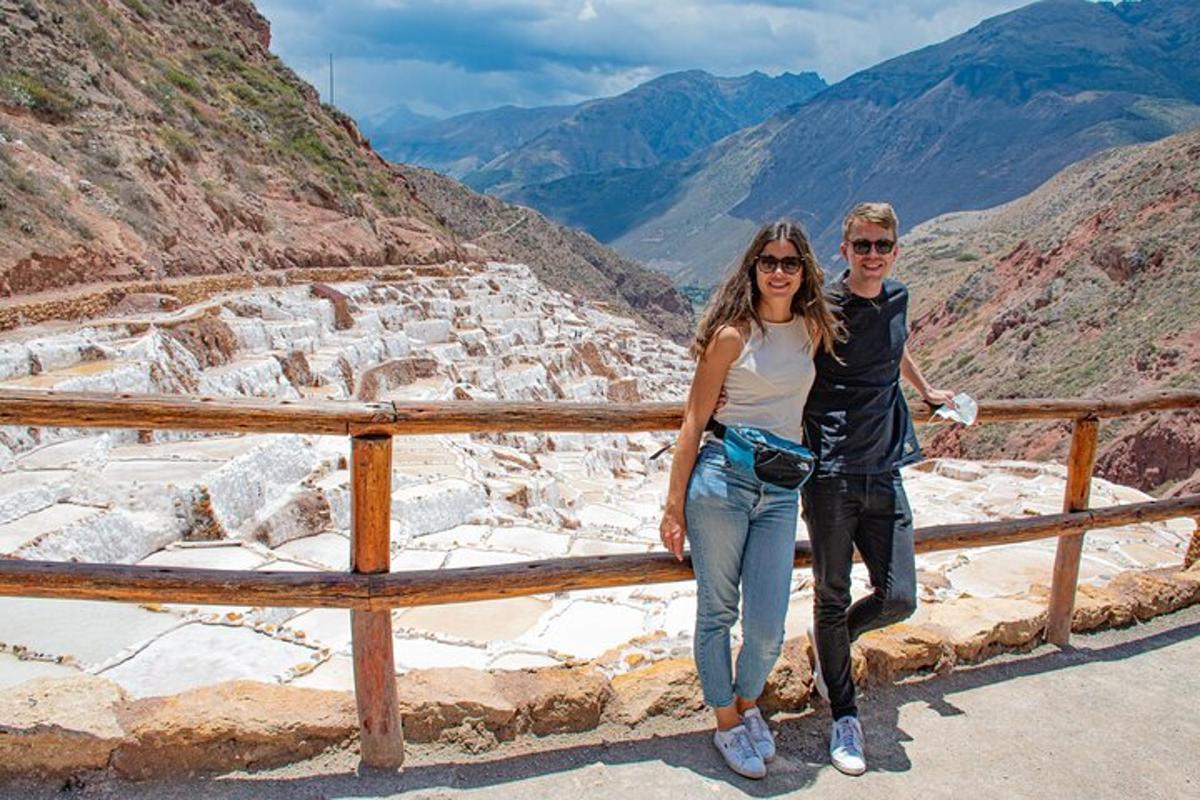 a man and a woman standing on a fence in the mountains