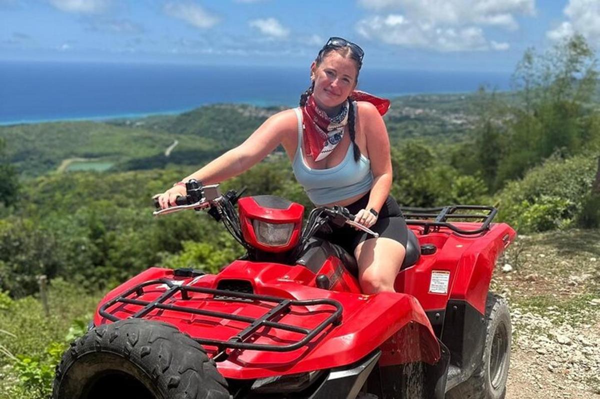 una donna sta guidando un quad su una collina