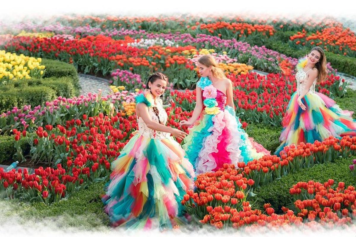Tres niñas con vestidos en un campo de tulipanes