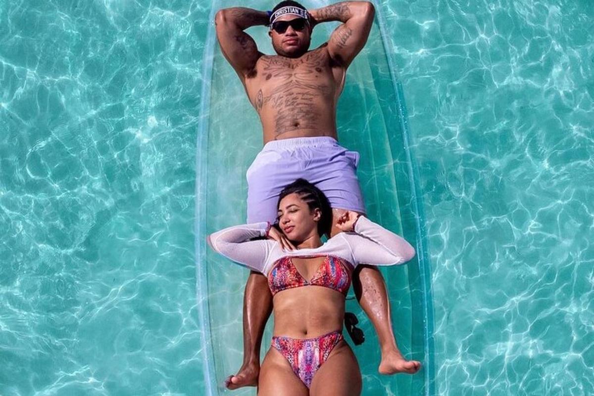 a man and woman laying on a surfboard in the water