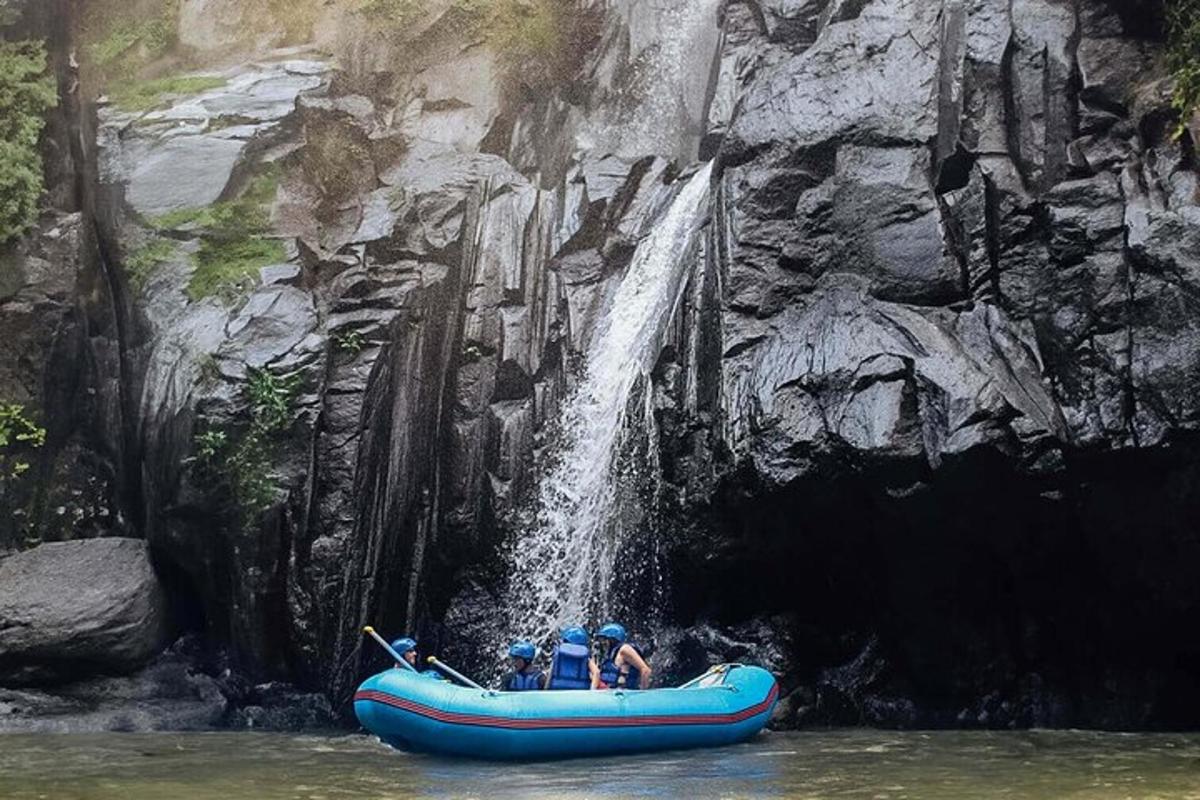 sekumpulan orang dalam rakit di hadapan air terjun