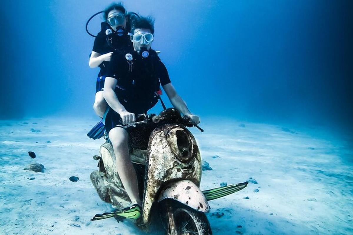 duas pessoas sentadas em uma scooter no oceano