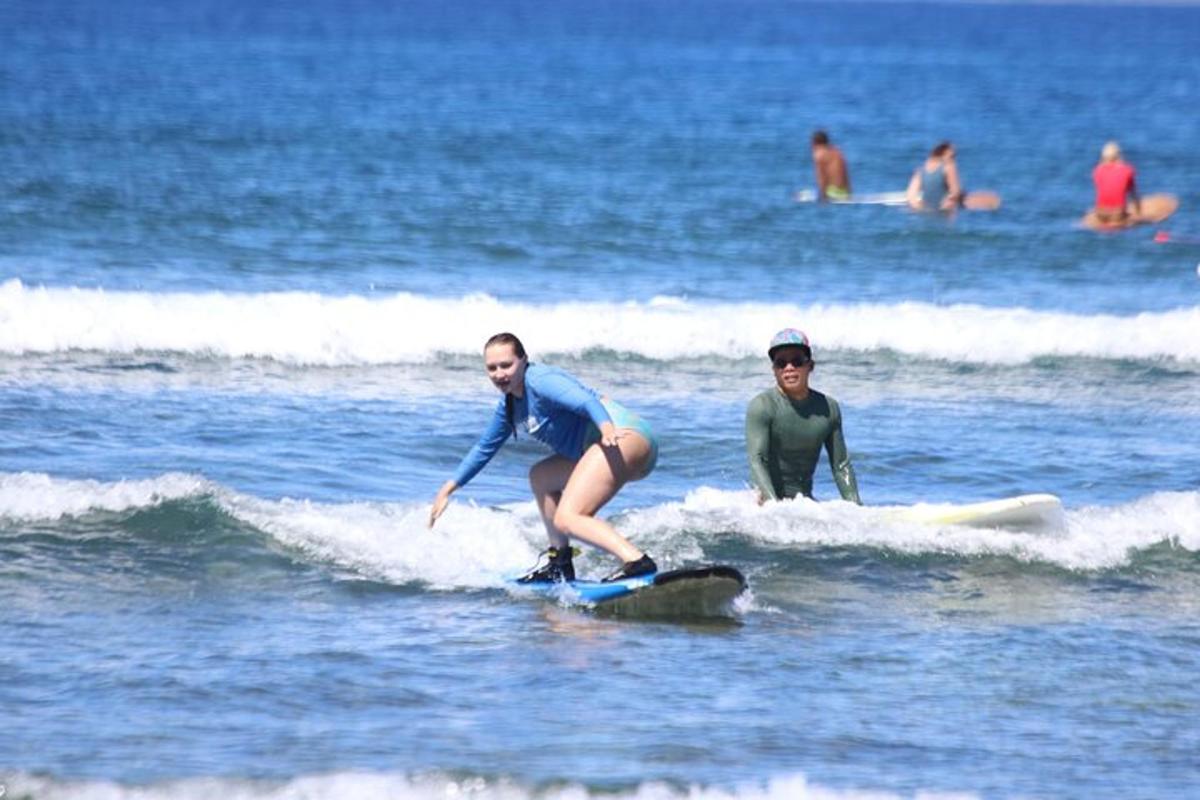 due donne cavalcano un'onda su tavole da surf nell'oceano