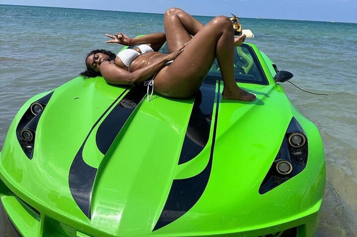 hai người nằm trên đỉnh một chiếc greenborghini trên bãi biển