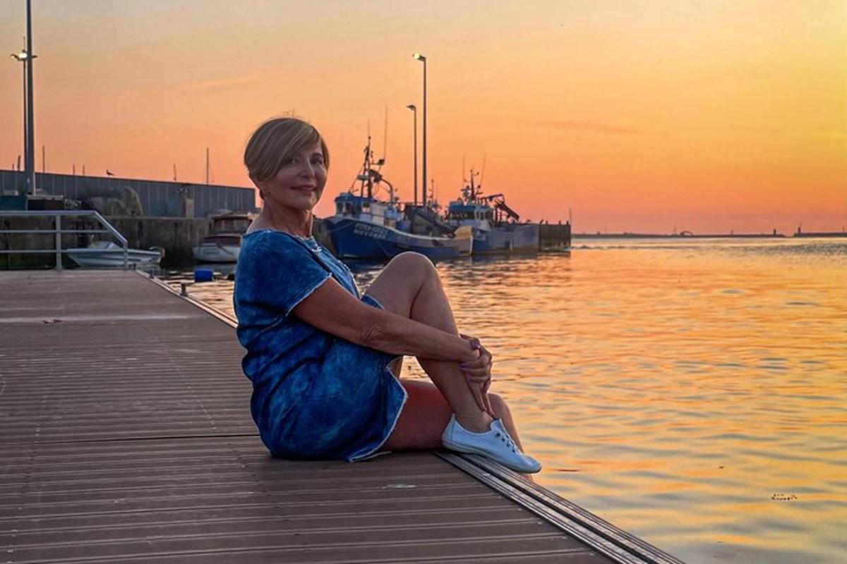 žena sjedi na doku blizu vode