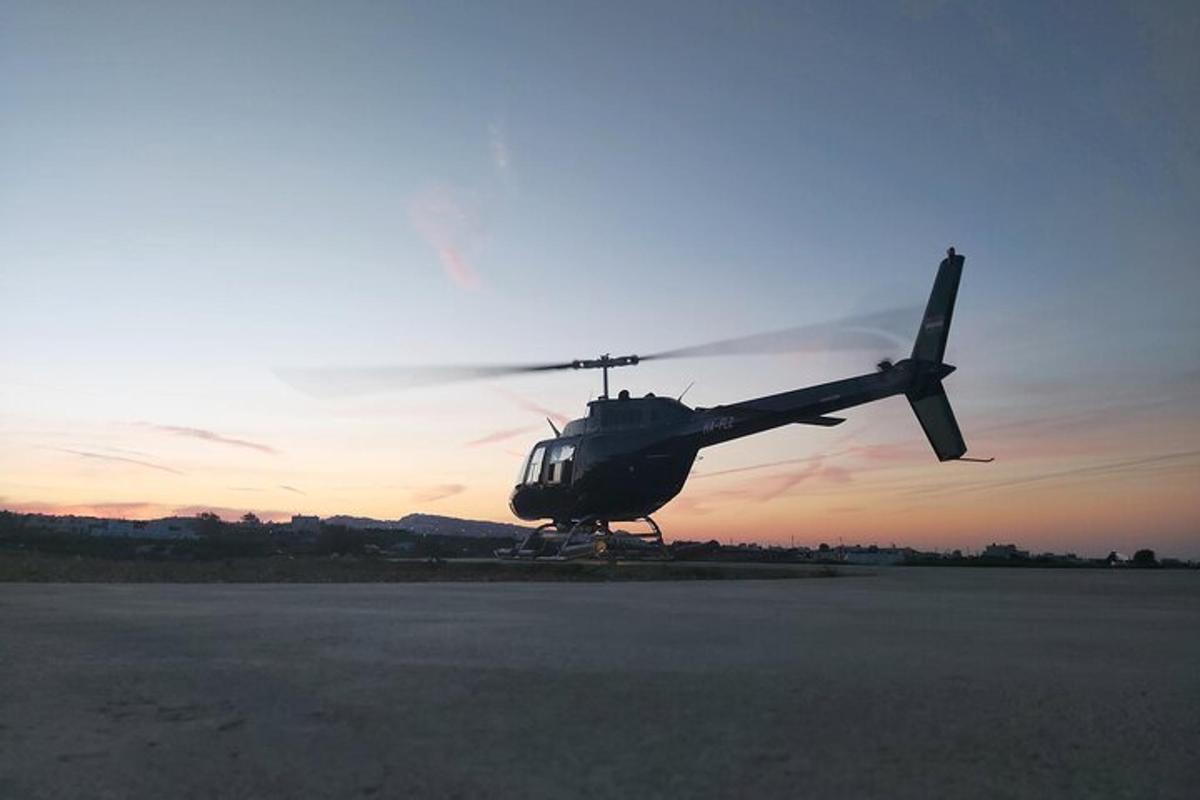 un elicottero fermo sulla pista al tramonto