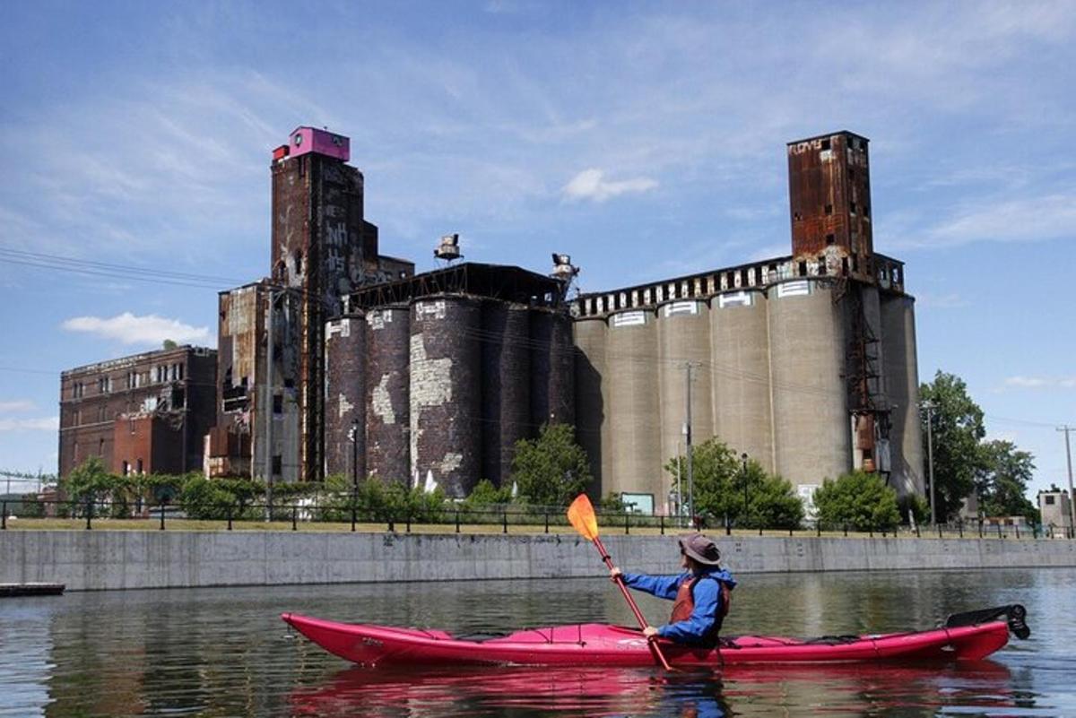 una persona en un caiac a l'aigua davant d'un edifici