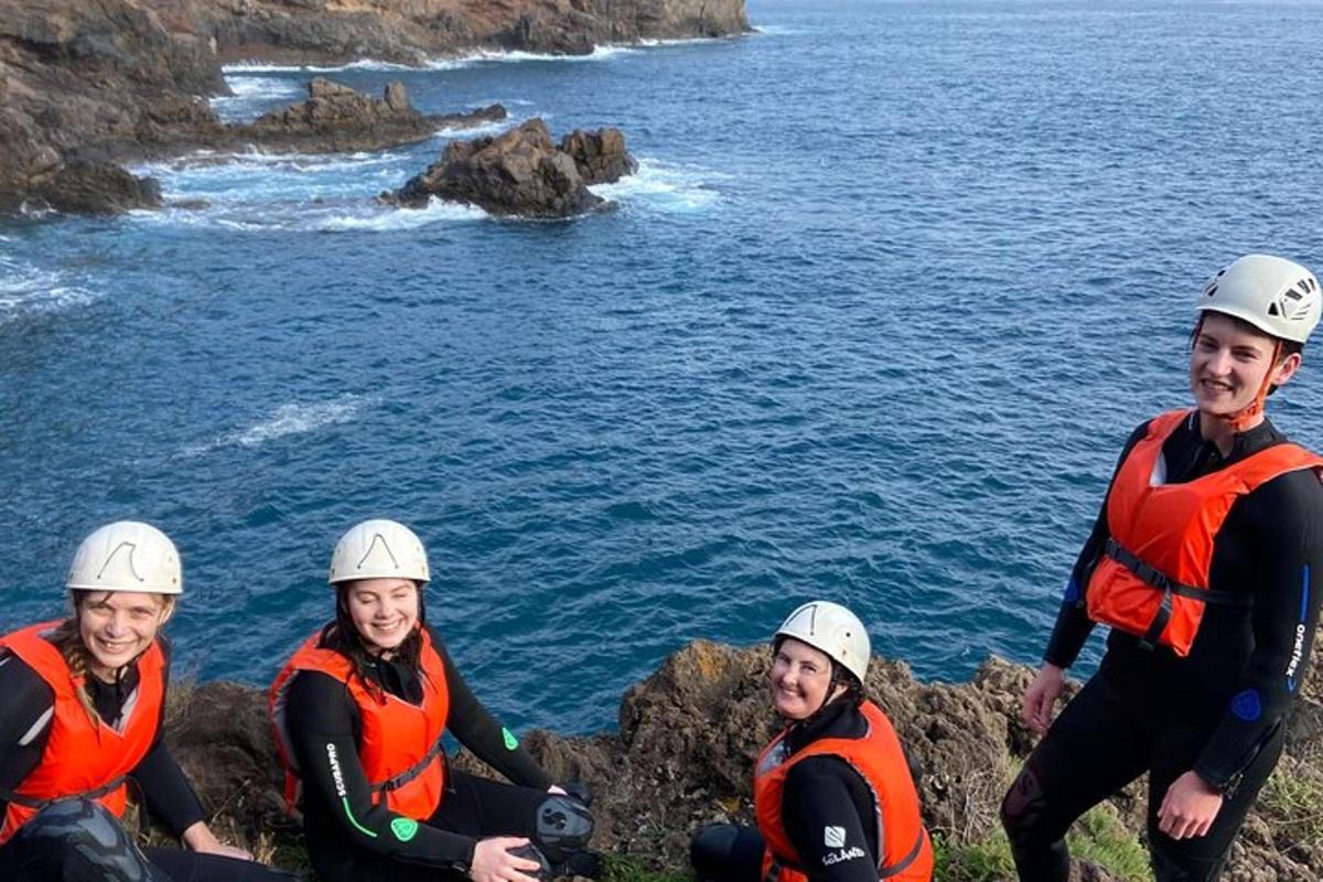 un grup de persones assegudes sobre roques vora l'aigua