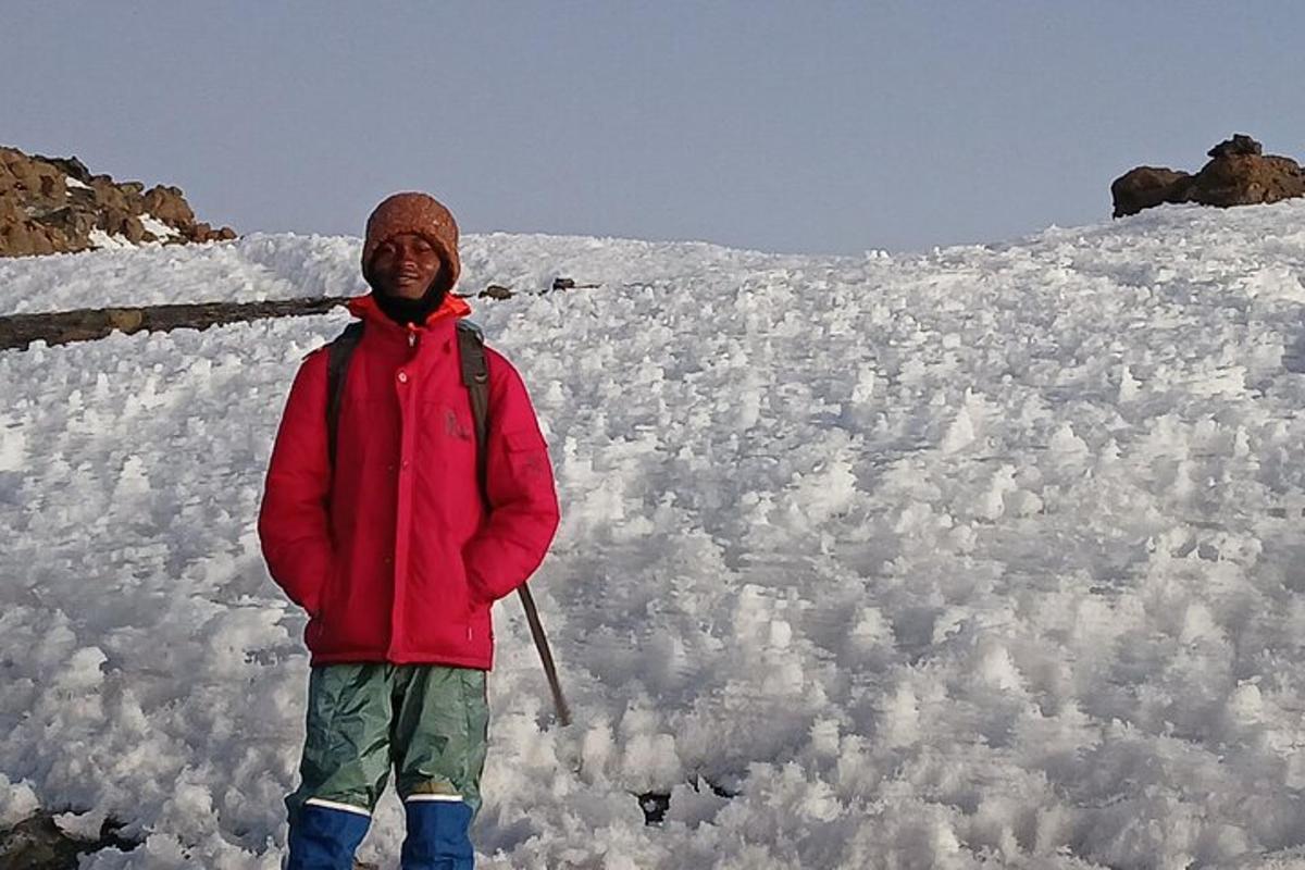 a man standing in front of a snow covered mountain