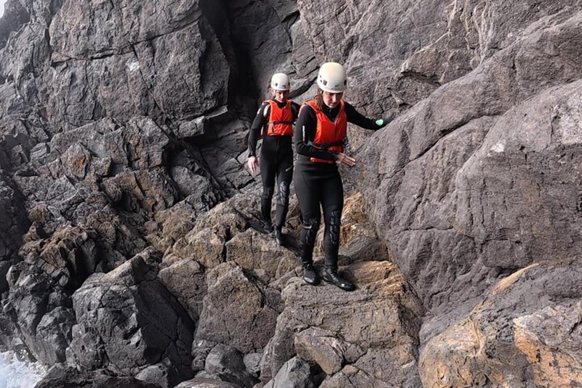 two people standing on the side of a rocky mountain