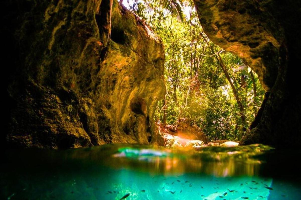 uma caverna com uma poça de água em frente a uma rocha