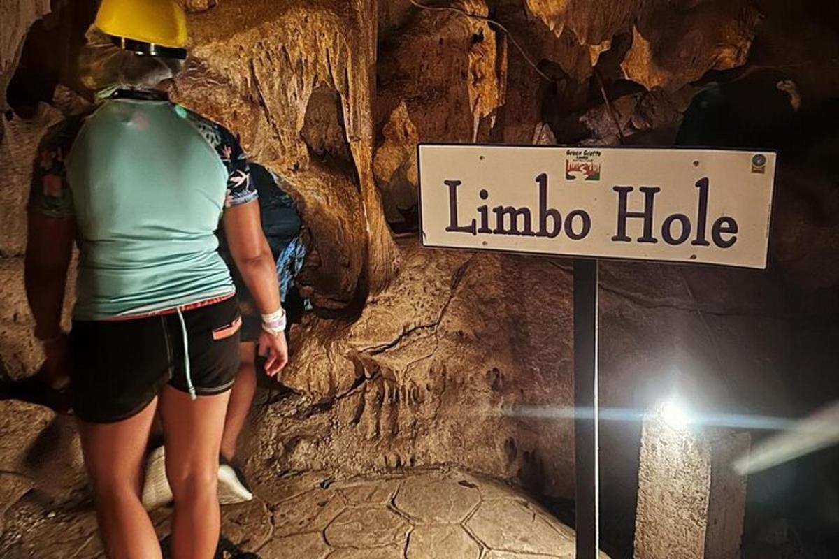 uma mulher parada ao lado de uma placa em uma caverna