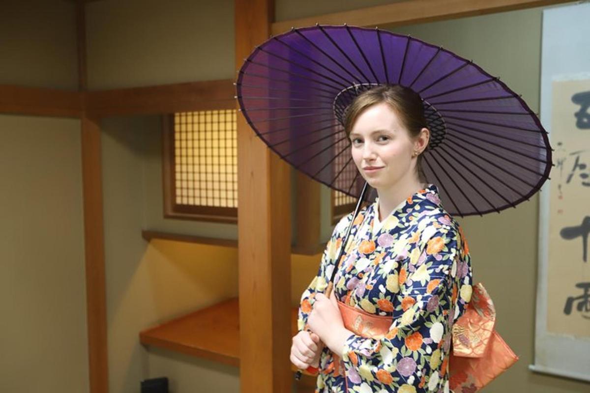 eine Frau im Kimono mit einem lila Regenschirm