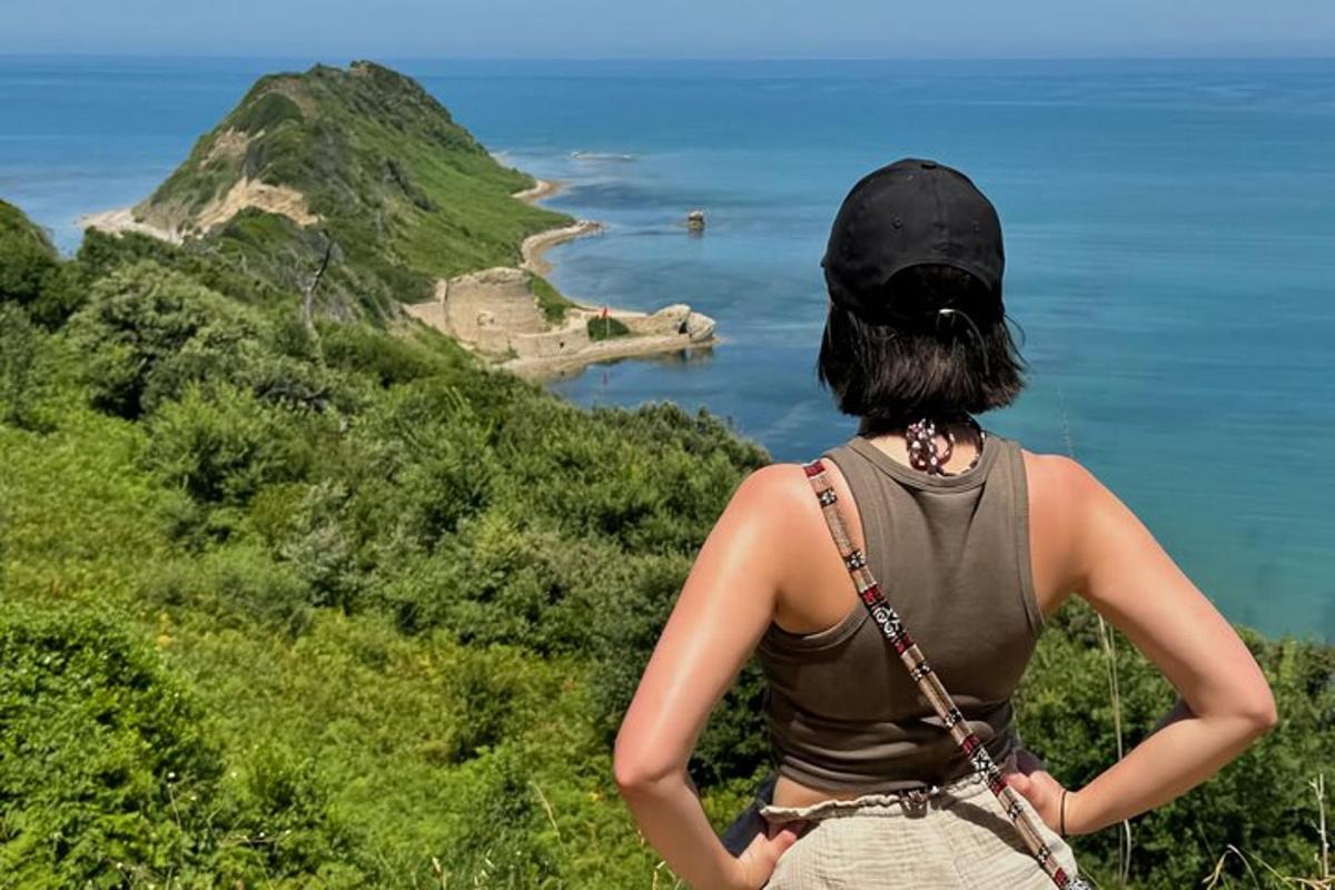 eine Frau, die auf einem Hügel steht und auf das Meer blickt