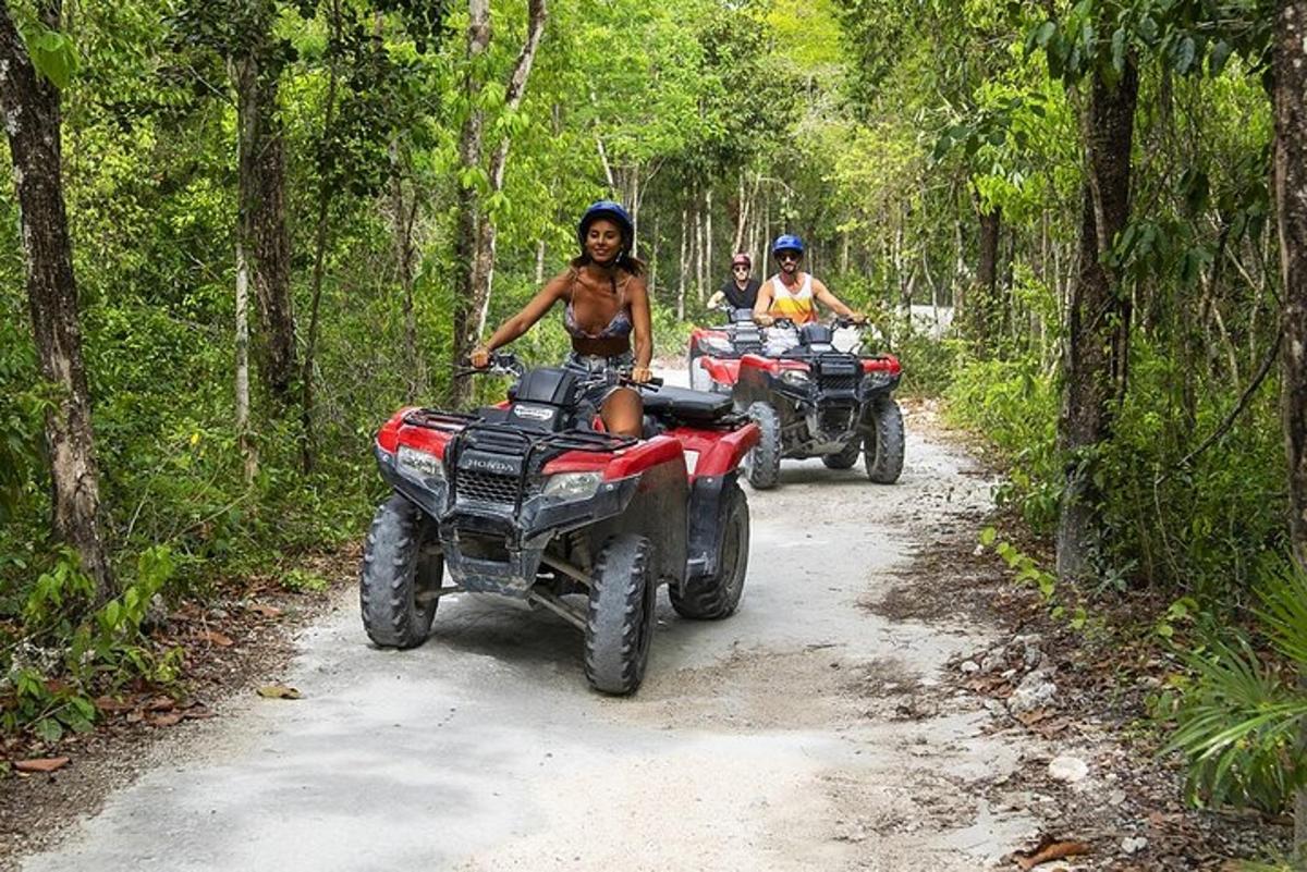 un grup de oameni care călătoresc cu ATV-uri pe un drum de pământ