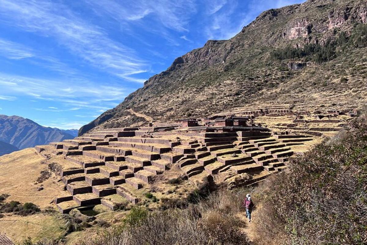 a person walking down a hill with a stone amphitheater