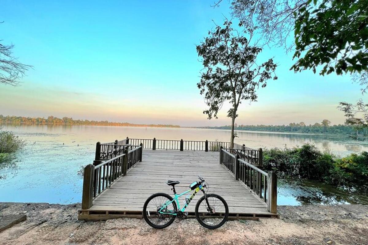 una bicicletta parcheggiata su un ponte di legno sopra un lago