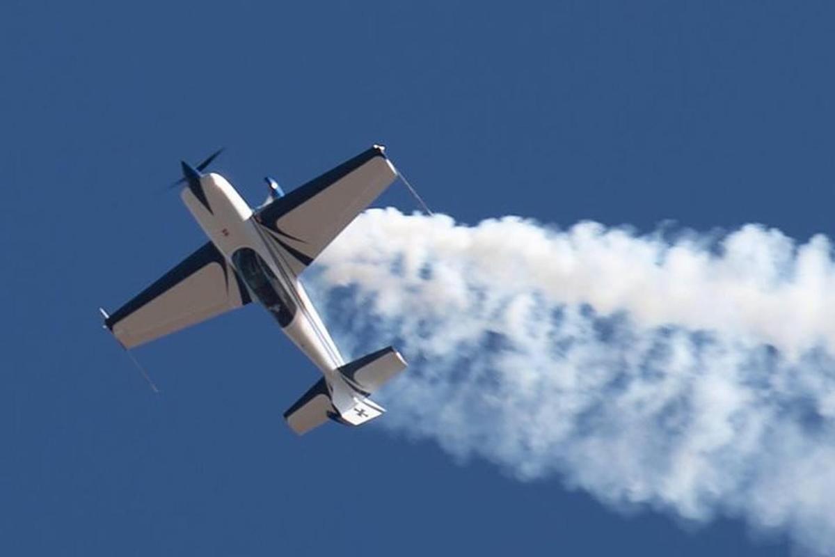 un avión volando en el cielo con humo