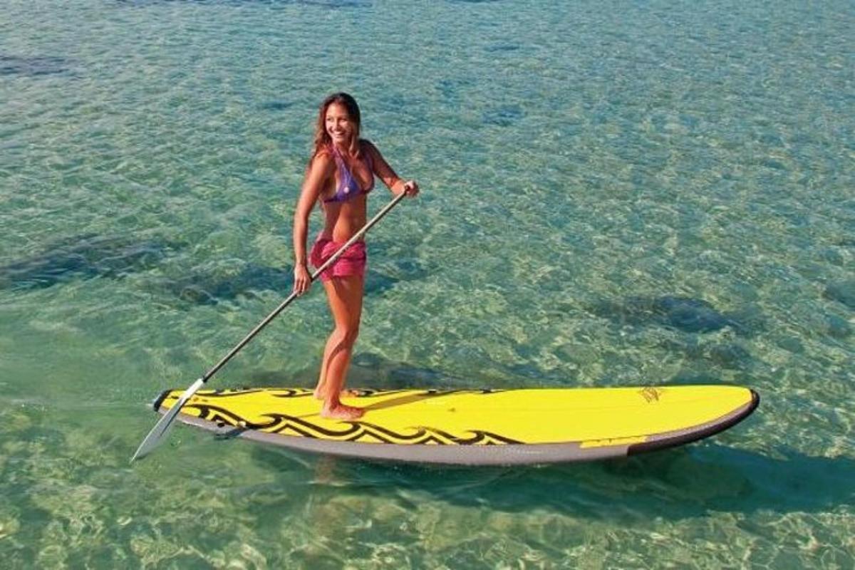 a girl is standing on a paddle board in the water