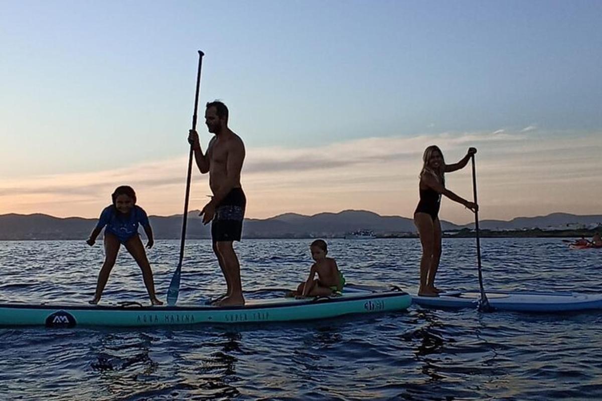 a group of people standing on a paddle board in the water