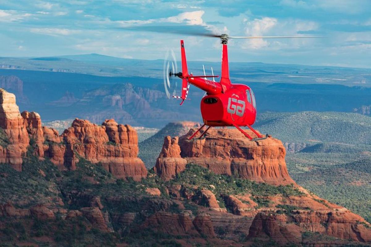 un elicopter roșu zburând peste Marele Canion