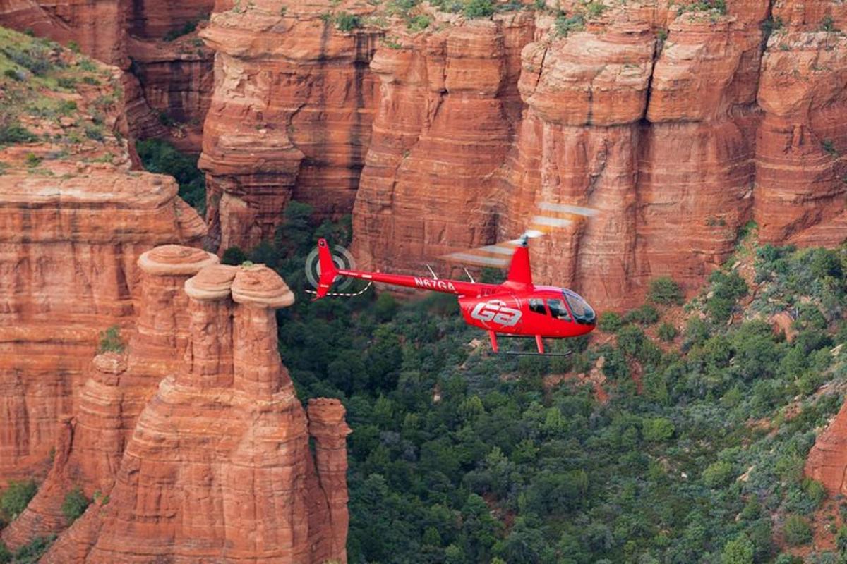 un elicopter roșu zboară peste un munte