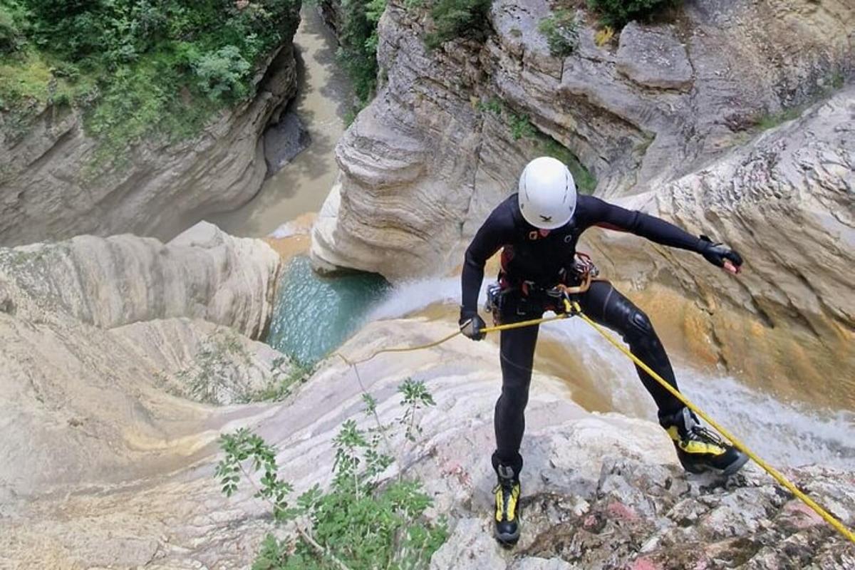 seorang lelaki sedang berdiri di atas batu di sungai