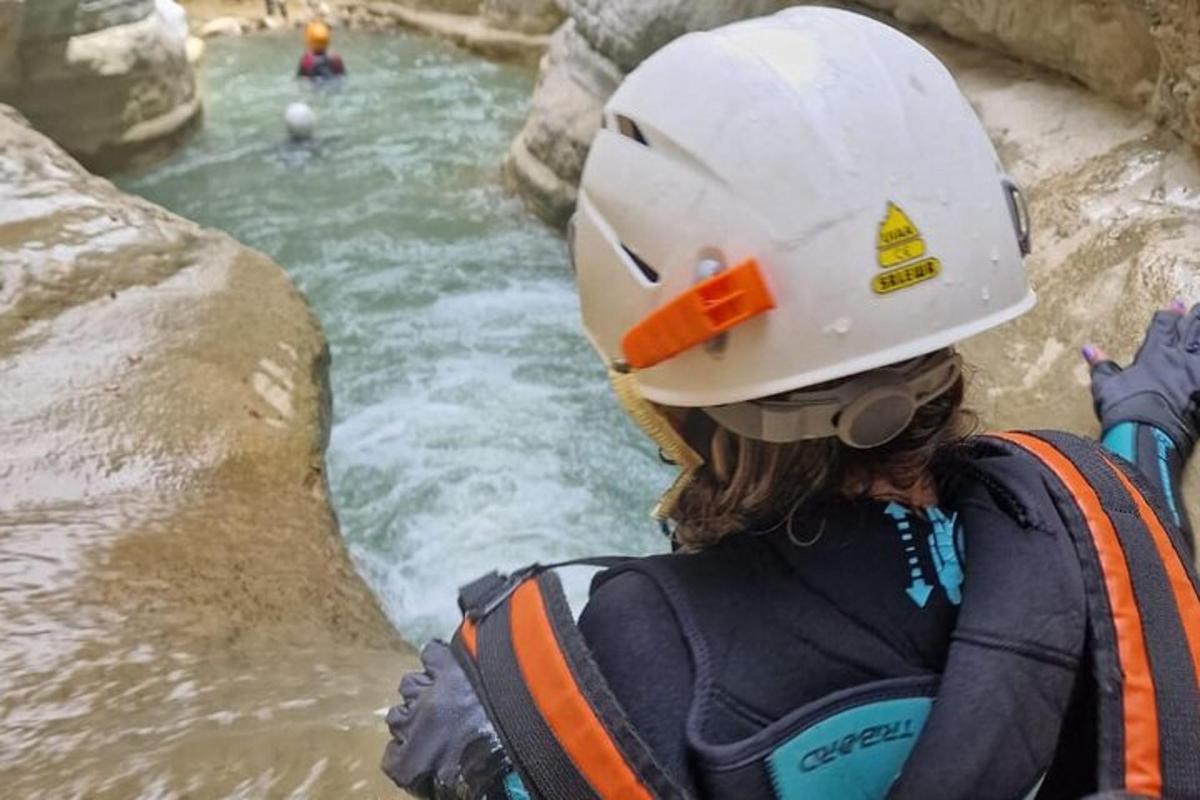seorang wanita memakai topi keras melihat sungai