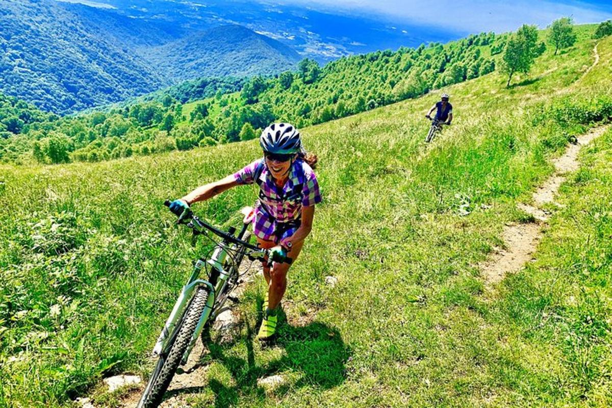 Una mujer montando en bicicleta en una colina cubierta de hierba