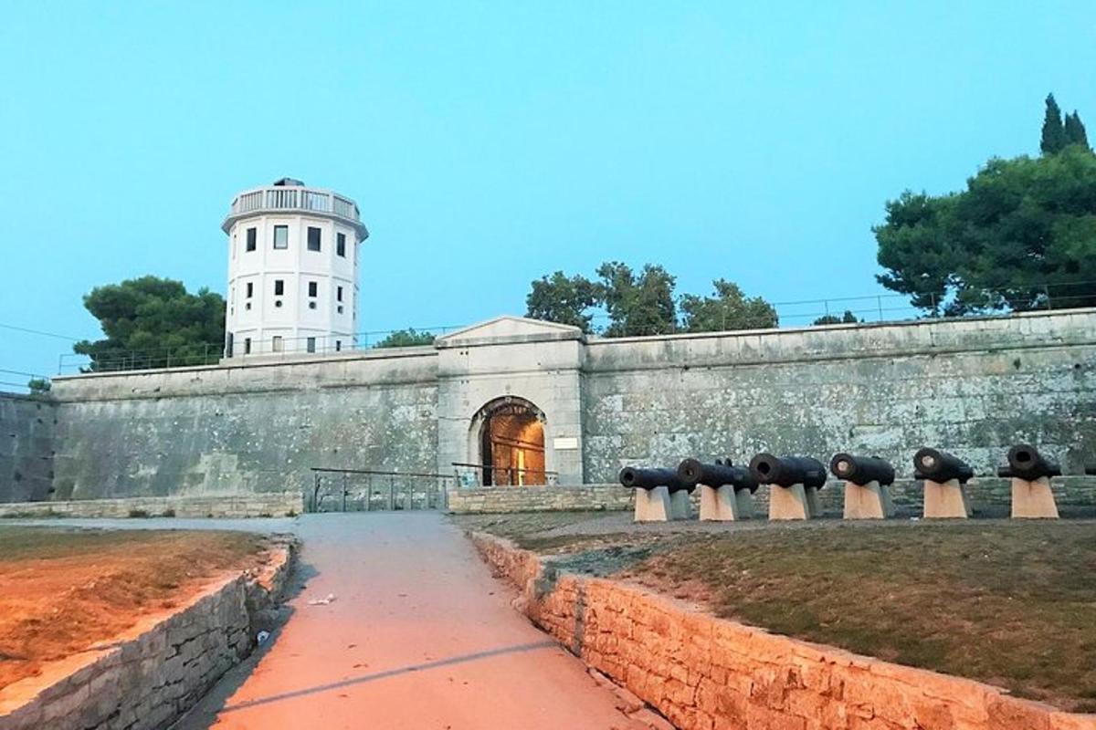 um muro de pedra com um farol ao fundo