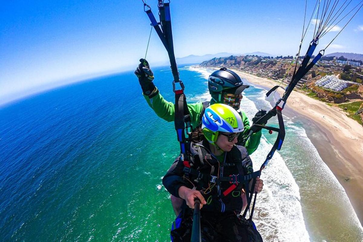 two people are riding a parachute over the ocean