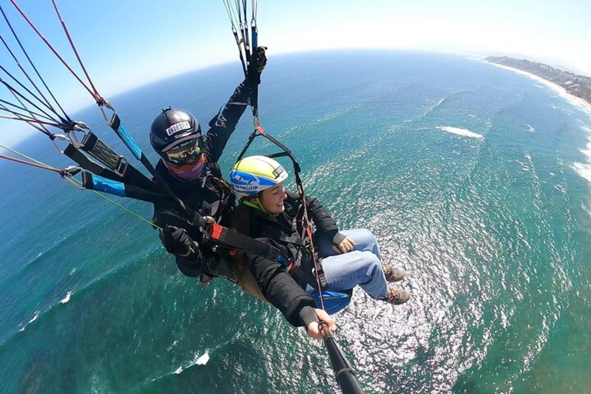 two people are riding a parachute over the ocean