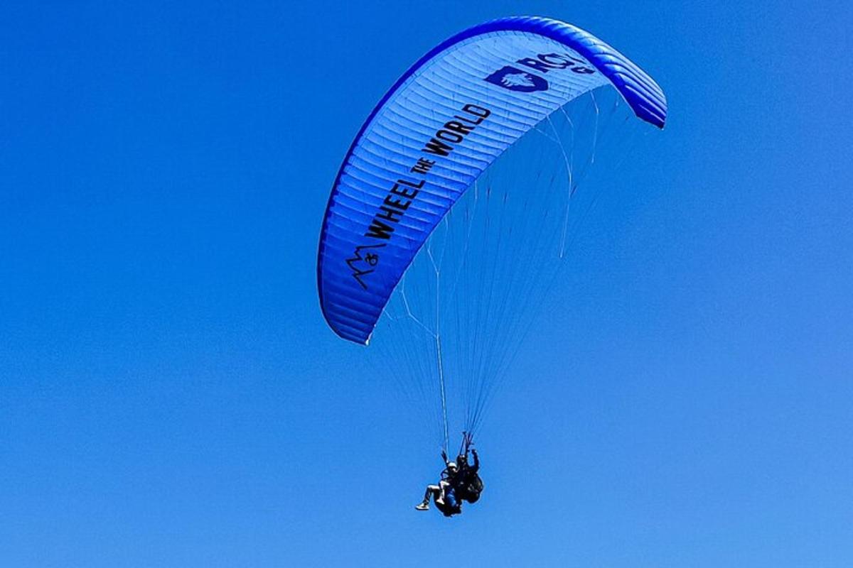a person riding a parachute in the sky