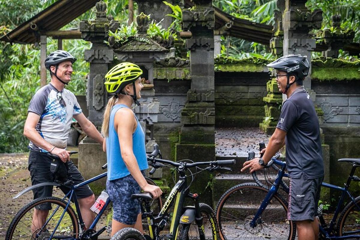 tre persone che indossano il casco in piedi accanto alle loro biciclette