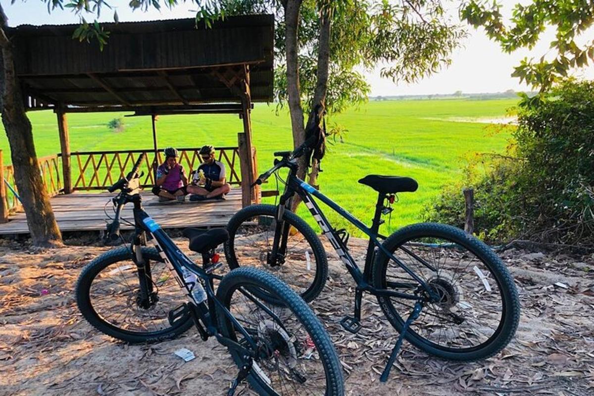 Dos bicicletas estacionadas frente a un porche con gente.