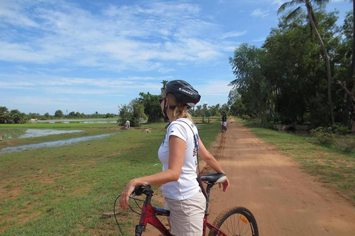 una mujer andando en bicicleta por un camino de tierra