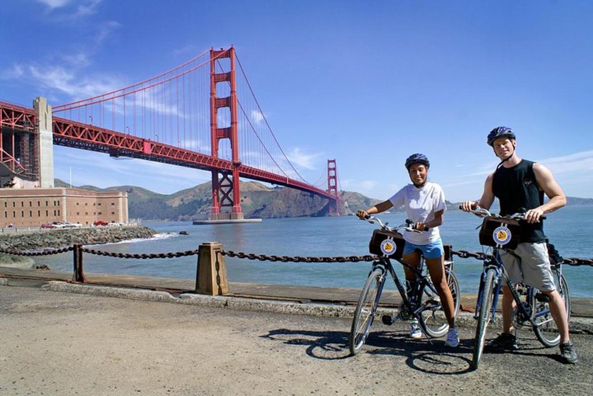 Dva muži na kolech před mostem Golden Gate